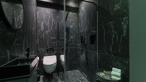 Ein modernes Badezimmer mit Marmorwaschbecken, Toilette und Dusche.