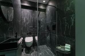 A modern bathroom with a marble sink, toilet, and shower. - The Galleries - Covent Garden - by Frankie (London)