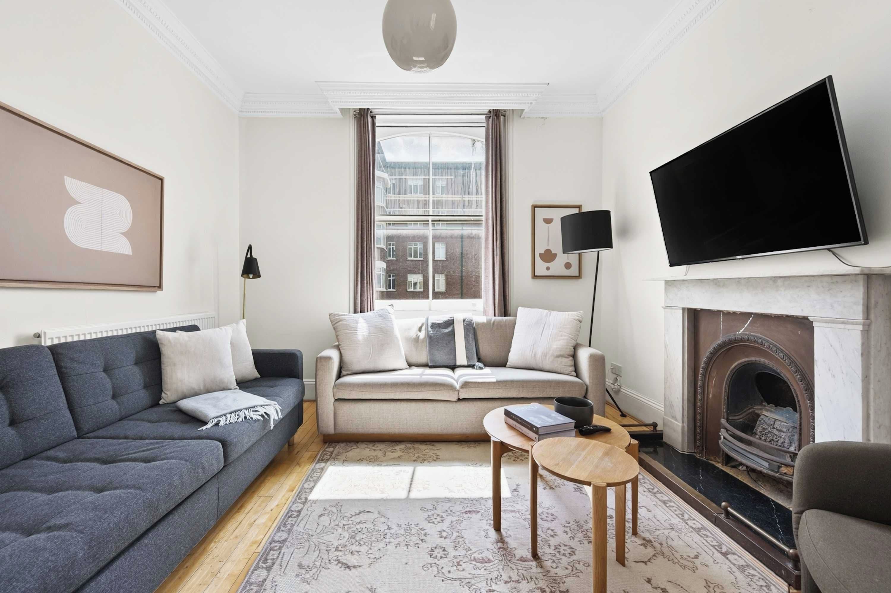 Una sala de estar moderna con un sofá, una mesa de centro, una chimenea y un televisor.