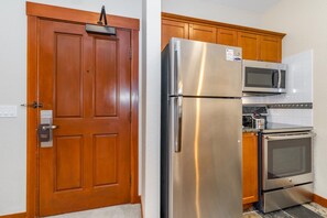A kitchen with a stainless steel refrigerator, a microwave, and an oven. - Palisades Ski Resort Condo | Steps to Gondola (Tahoe City)