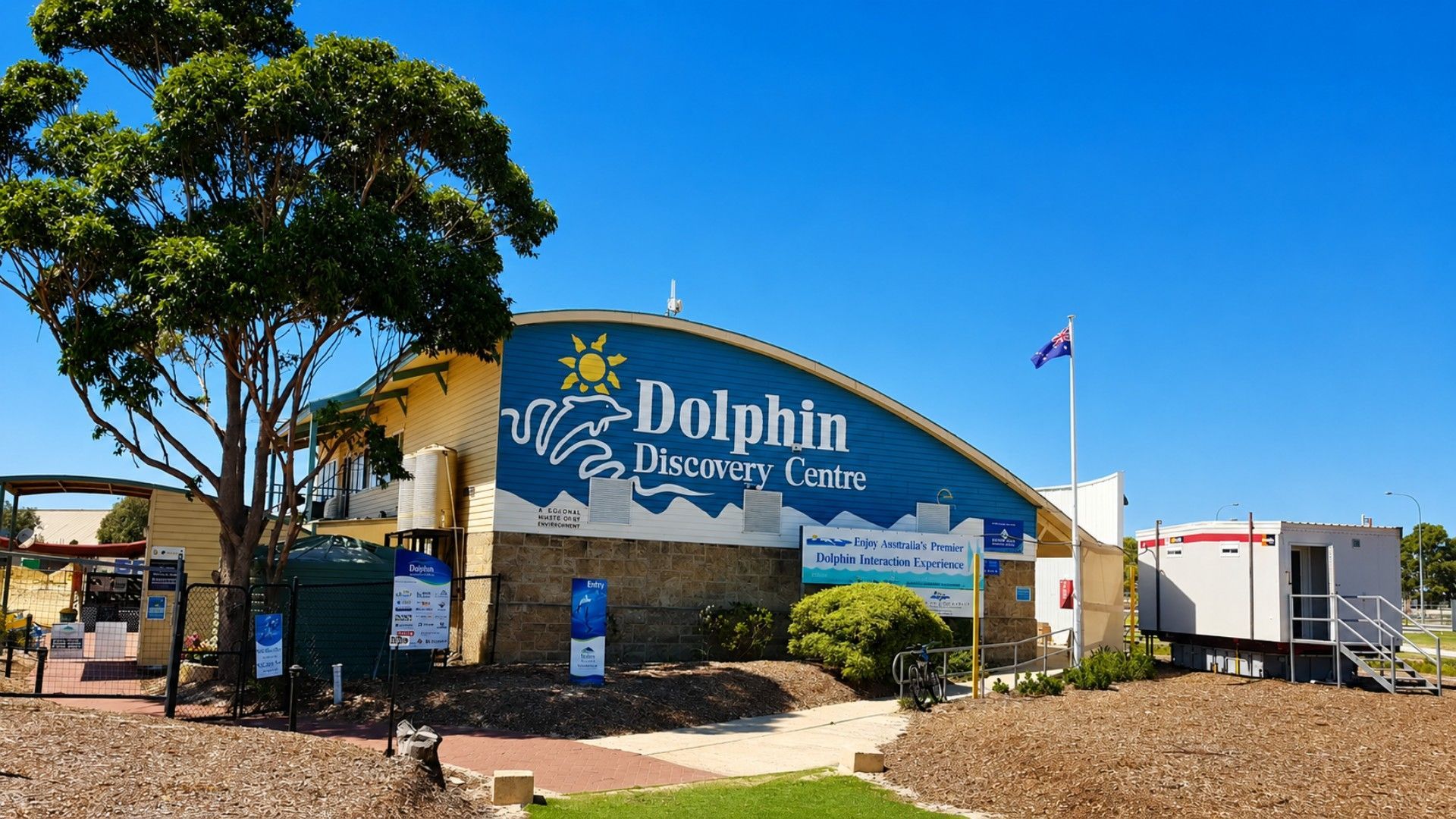 Un centre d’observation des dauphins, avec une grande enseigne, un drapeau et un ciel d’un bleu éclatant.