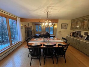 Un coin repas avec une table en bois, des chaises et un lustre.