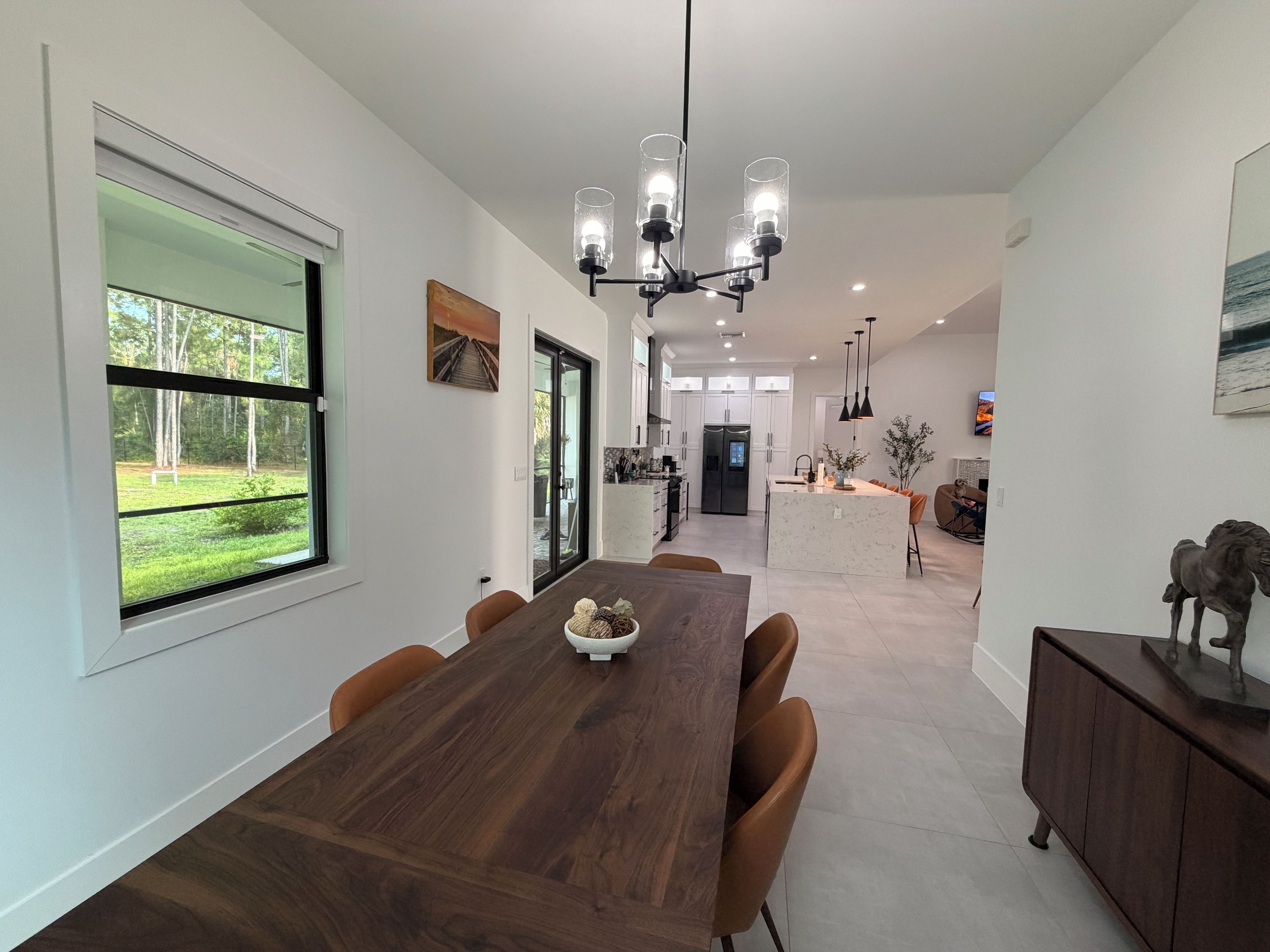 Una cocina moderna con una isla central, mesa de comedor y sillas.