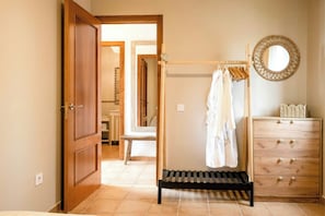Une pièce avec une porte en bois, un banc, un miroir et une commode à tiroirs.