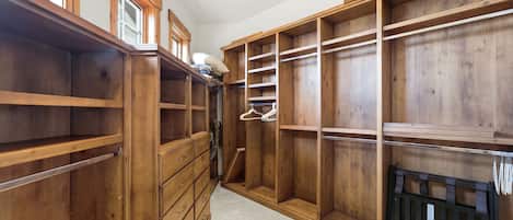 A walk-in closet with wooden shelving, drawers, and hanging space.