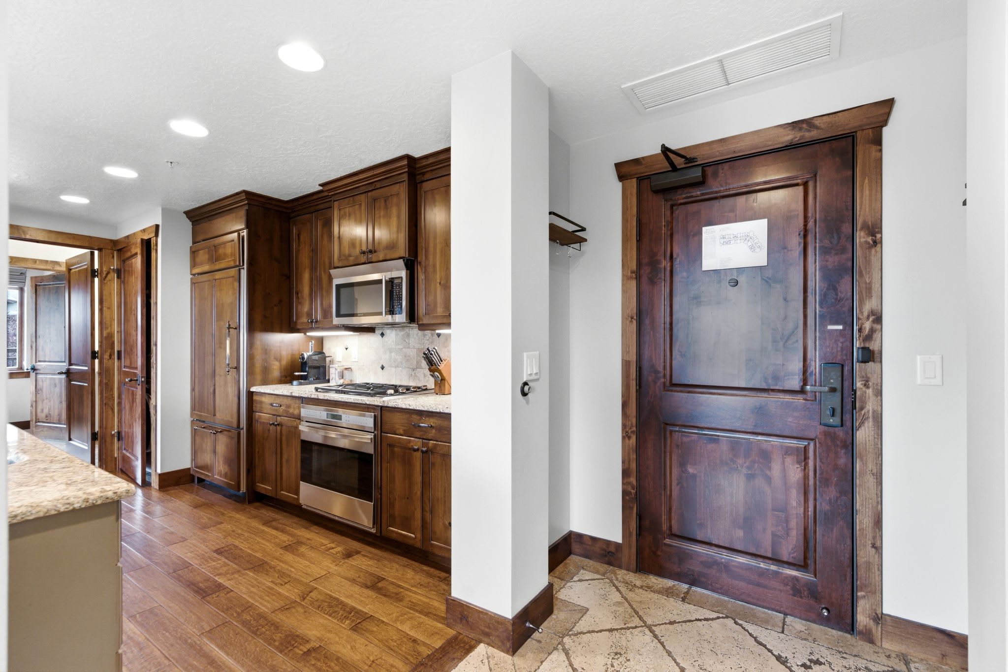 A kitchen with wooden cabinets, a microwave, stove, and oven.