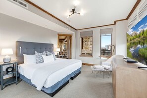 A hotel room with a large bed, a desk, a chair, and a view of a mountain landscape. - Ski-in/Ski-out | Heated Pool, Hot Tubs & Game Room | Shuttle To Main St. (Park City)
