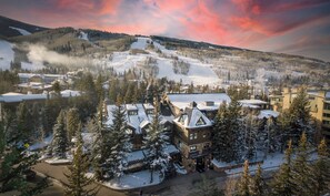 Un complejo turístico en la montaña, cubierto de nieve, con edificios y pistas de esquí.