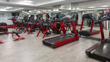 A gym with treadmills, ellipticals, and free weights.