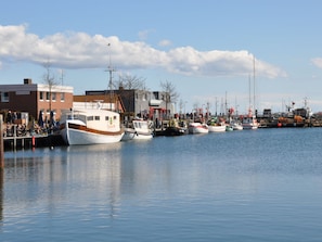 A marina with several boats docked, a building with a sign, and a clear sky. - Holiday Apartment With 1 Bedroom (Heiligenhafen)