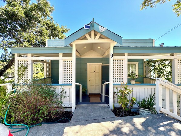 A two-story house with a porch, a door, and a number '9' on the wall.