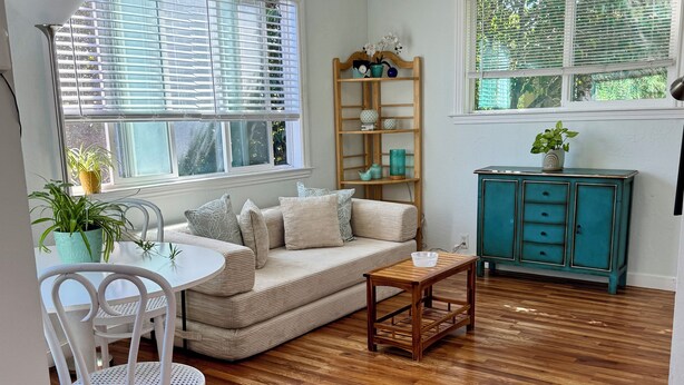 A cozy living room with a sofa, coffee table, and a wooden cabinet.