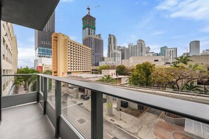 A balcony with a view of a cityscape, including high-rise buildings and a construction crane. - 501 First Studio Balcony by Palermo Home (Miami)