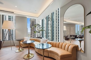 A modern living room with a sofa, two round tables, a floor lamp, and a large mirror. - 501 First Studio Balcony by Palermo Home (Miami)