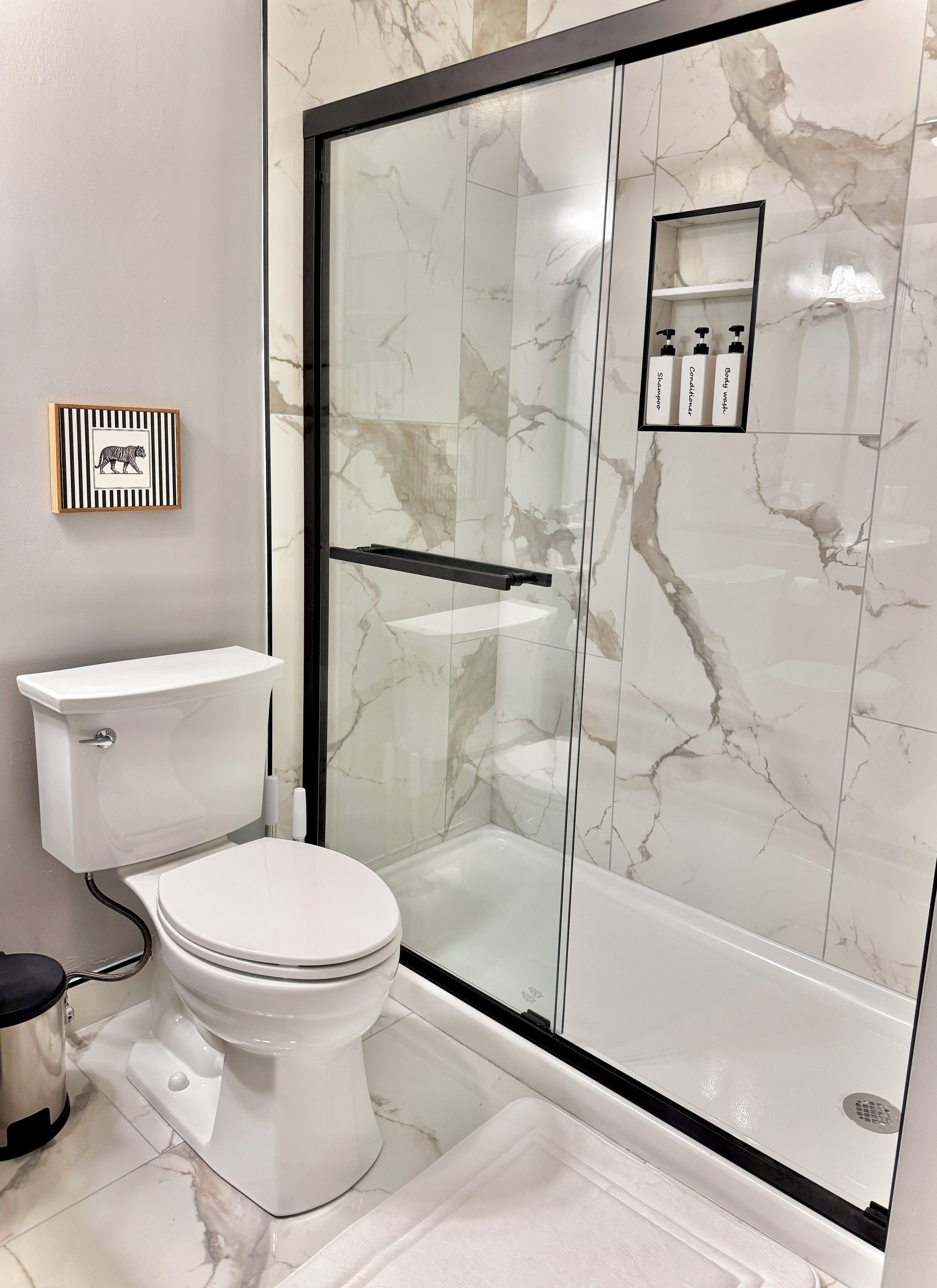 Ein modernes Badezimmer mit Toilette, Dusche und einer gläsernen Duschkabine.