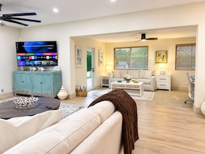 A living room with a sofa, coffee table, and a television displaying a menu.