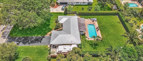 Un barrio residencial con varias casas, una piscina y céspedes cuidados.