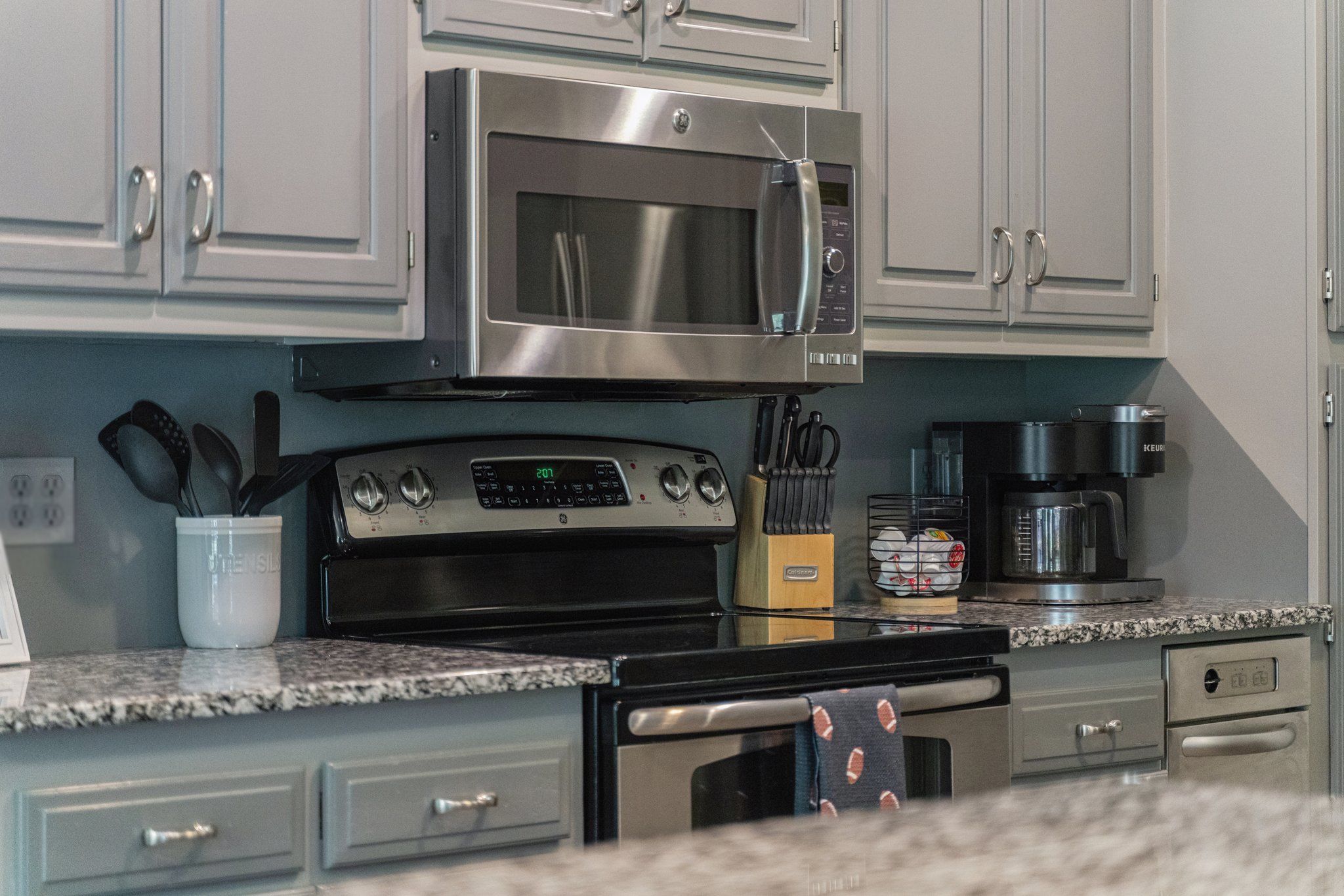 A kitchen with stainless steel appliances, including a microwave, oven, and coffee maker.