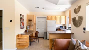 A compact kitchen with a refrigerator, microwave, and wooden cabinets.