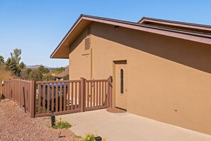 A building with a beige exterior, a brown wooden gate, and a door with a window.