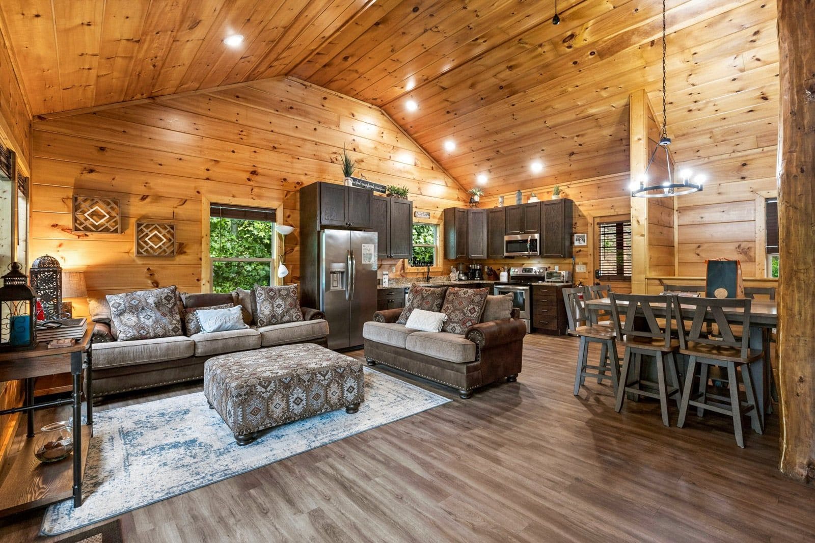 A log cabin interior with a living room, dining area, and kitchen.