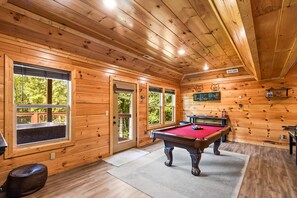 A wooden interior with a pool table, windows, and a fireplace. - The Sporting Place - Outdoor Hot Tub, Firepit, Game Room + Close to Pigeon Forge (Sevierville)