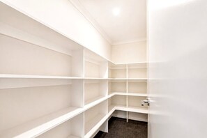 Un armari blanc amb diverses prestatgeries i una porta.