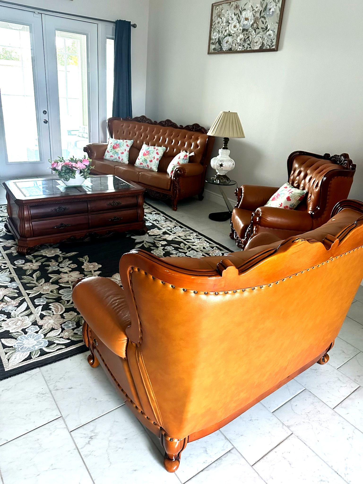 A living room with a brown sofa set, a coffee table, and a patterned rug.