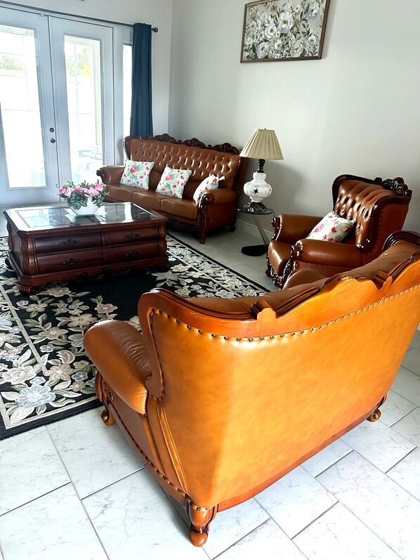 A living room with a brown sofa set, a coffee table, and a patterned rug.