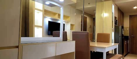 Una cocina moderna con comedor, electrodomésticos integrados y un espejo grande.