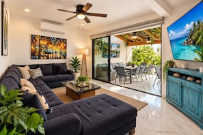 A modern living room with a sectional sofa, a coffee table, and a TV on a stand. - Private Boutique Hotel Buyout & Luxury (Puerto Vallarta)