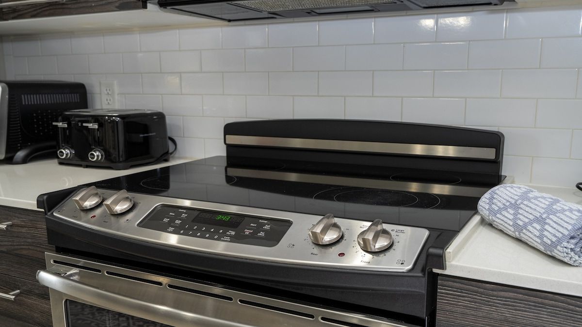 A kitchen with a stainless steel stove, a toaster, and a microwave.