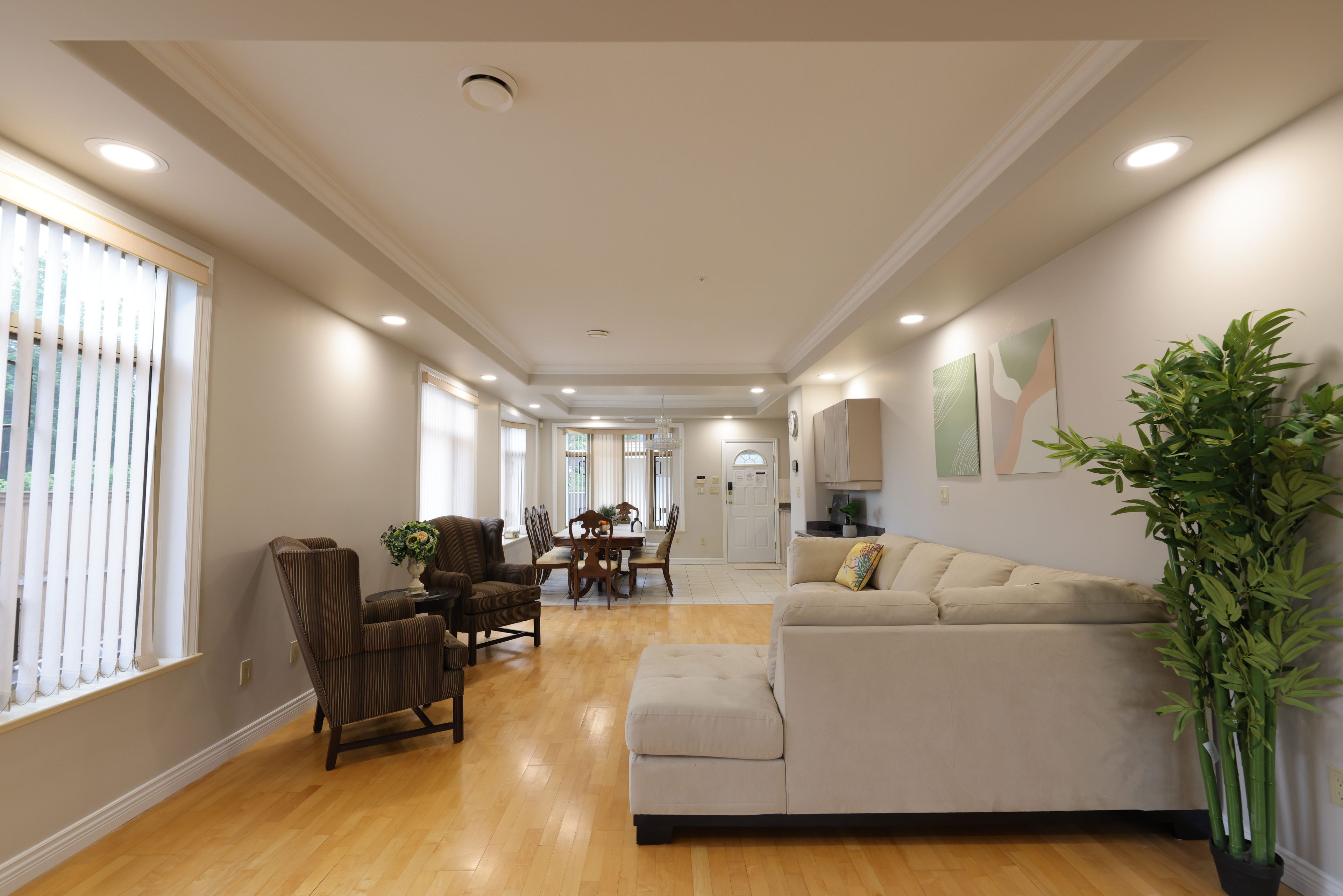 A spacious living room with a sofa, chairs, and a dining area.