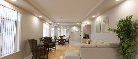 A spacious living room with a sofa, chairs, and a dining area.