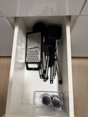 A drawer containing a grater, a set of utensils, and a container with lids. - [New] Ocean View 2 bedroom 2 bath in Waikiki (Honolulu)
