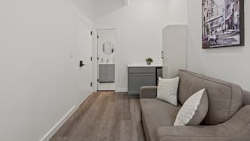 A modern interior with a grey sofa, a small table, and a painting on the wall.