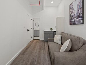 A modern interior with a grey sofa, a small table, and a painting on the wall.