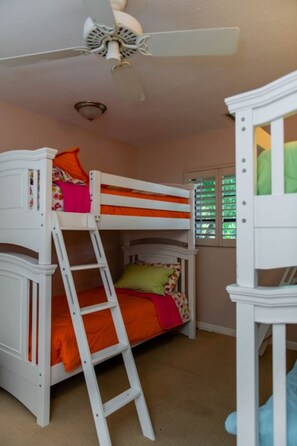 A bunk bed with a ladder, a ceiling fan, and a window with blinds. - Coral Sunset in Islamorada (Tavernier)