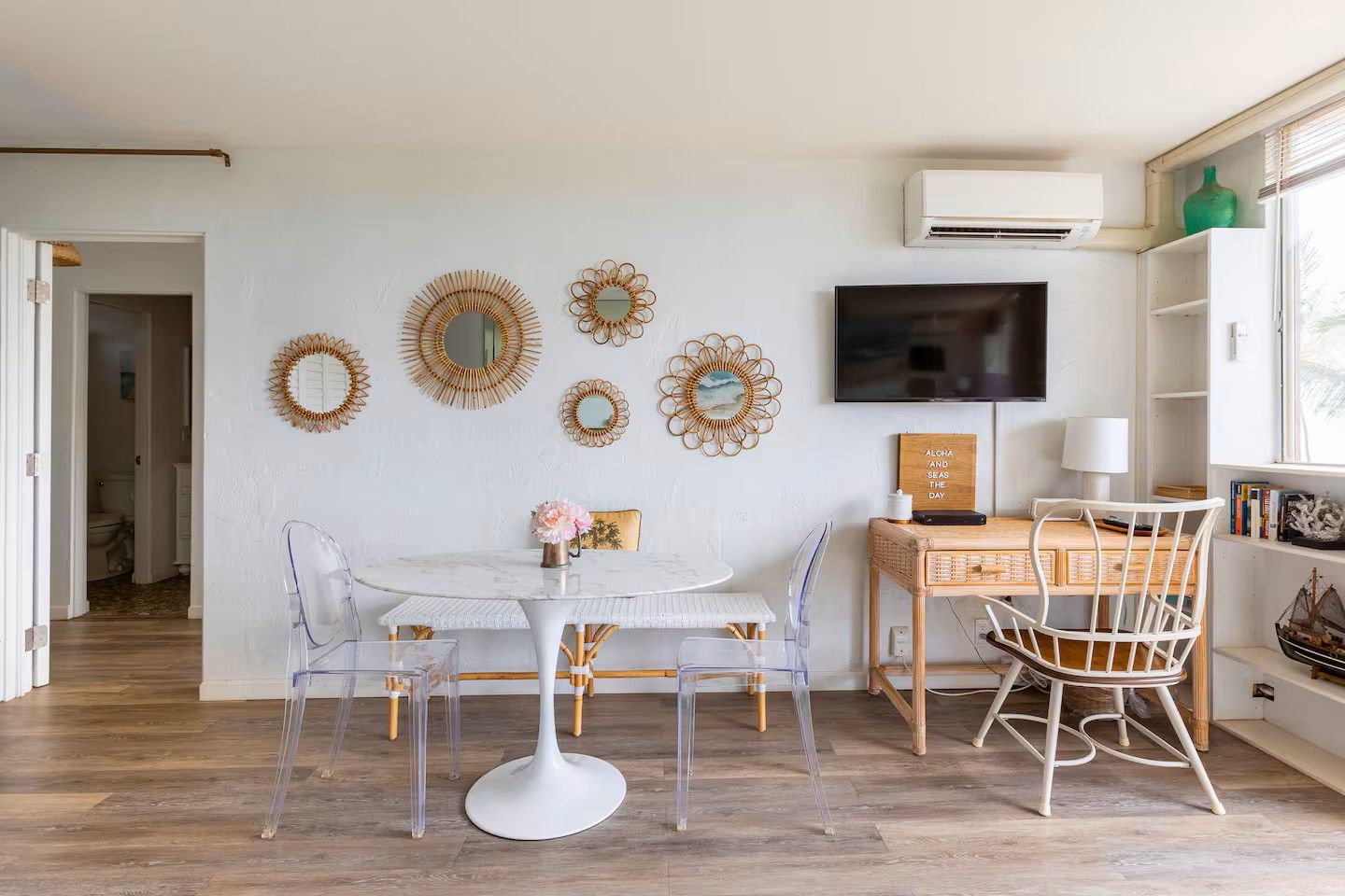 A dining area with a round table, chairs, and wall decorations.