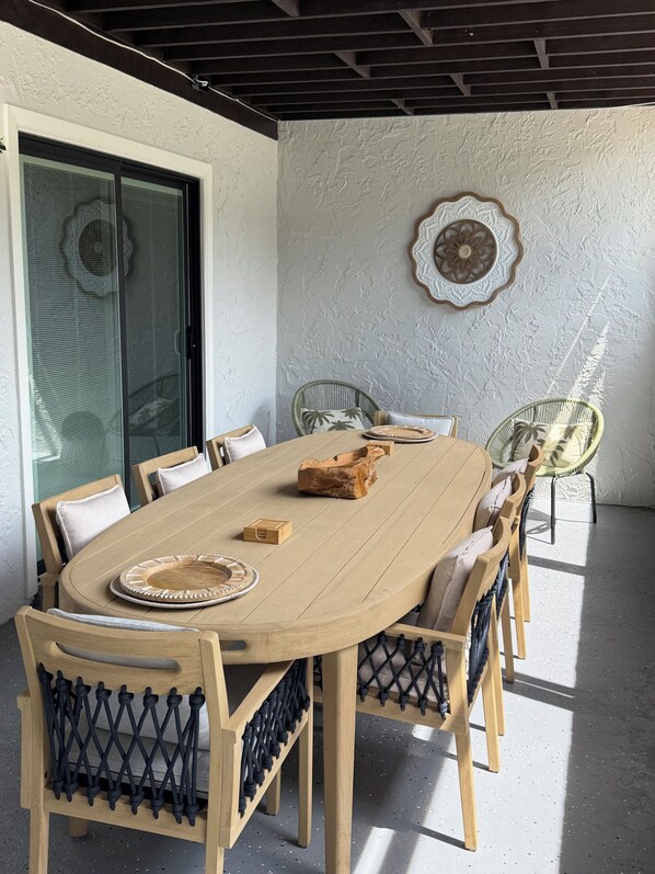 A dining area with a round wooden table, six chairs, and a glass door.