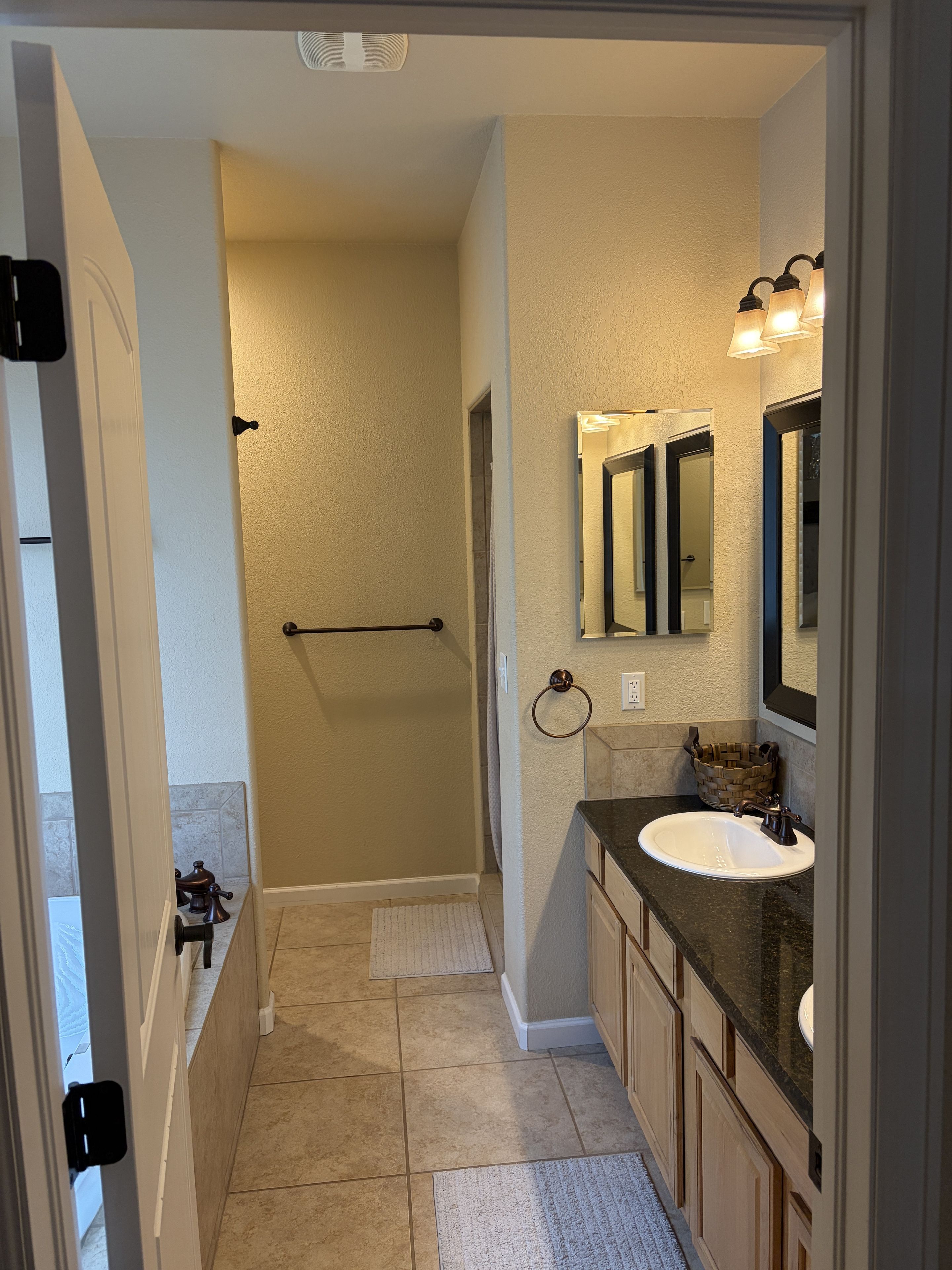 Une salle de bain avec une douche, un lavabo et un miroir.