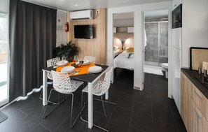 Une chambre d’hôtel moderne comprenant un coin repas, un lit et une douche.