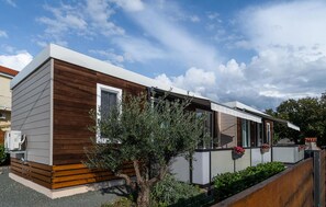 Ein modernes Einfamilienhaus mit Holzfassade, großen Fenstern und einem kleinen Garten.