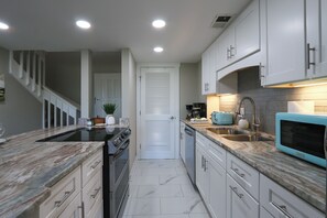 A modern kitchen with white cabinetry, a built-in oven, and a microwave. - Walk to Beach & Coligny/King Bed/Pickleball/Pool (Hilton Head Island)