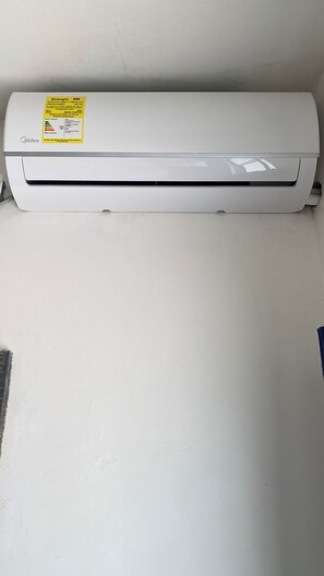 A white wall-mounted air conditioner with a yellow label.