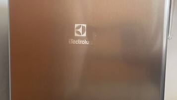 Ein Edelstahl-Kühlschrank mit dem Electrolux-Logo, platziert auf einer Metallkiste.