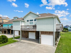 Ein zweistöckiges Wohnhaus mit Garage, überdachter Veranda und kleiner Terrasse.