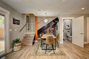 A modern interior with a staircase, dining area, and a view of the outdoors. - Hot Tub • Greenbelt• Fireplace • Telescope • Pets (Garden City)