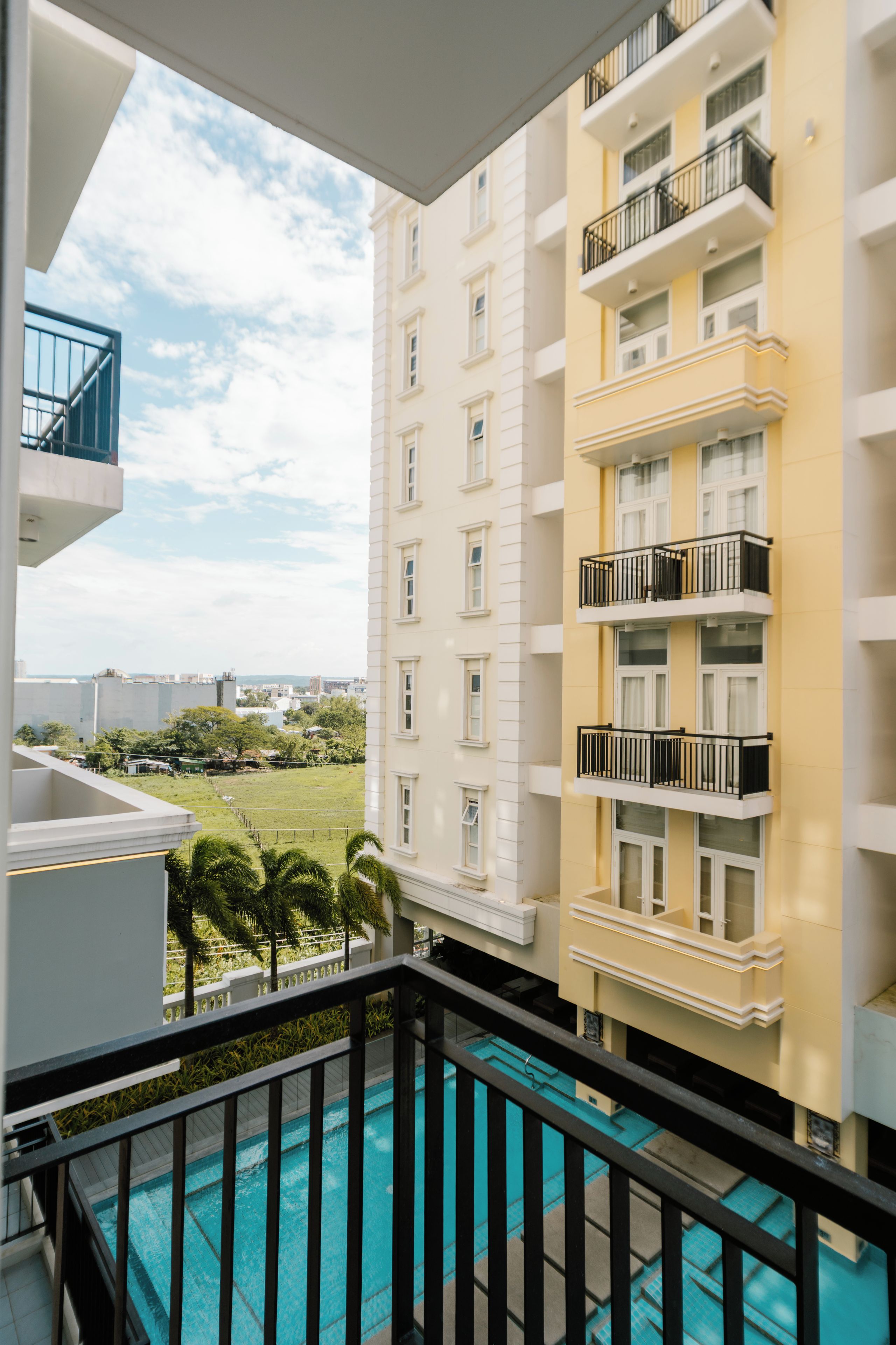 A residential building with multiple balconies and a swimming pool.