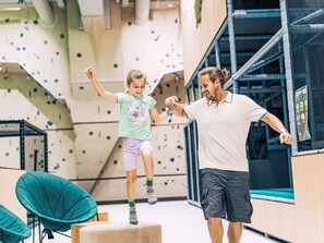 Eine Kletterwand mit Griffen und einer gepolsterten Landefläche.